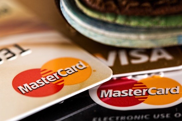 Kreditkarten von MasterCard und Visa liegen unter einem Portemonnaie 
